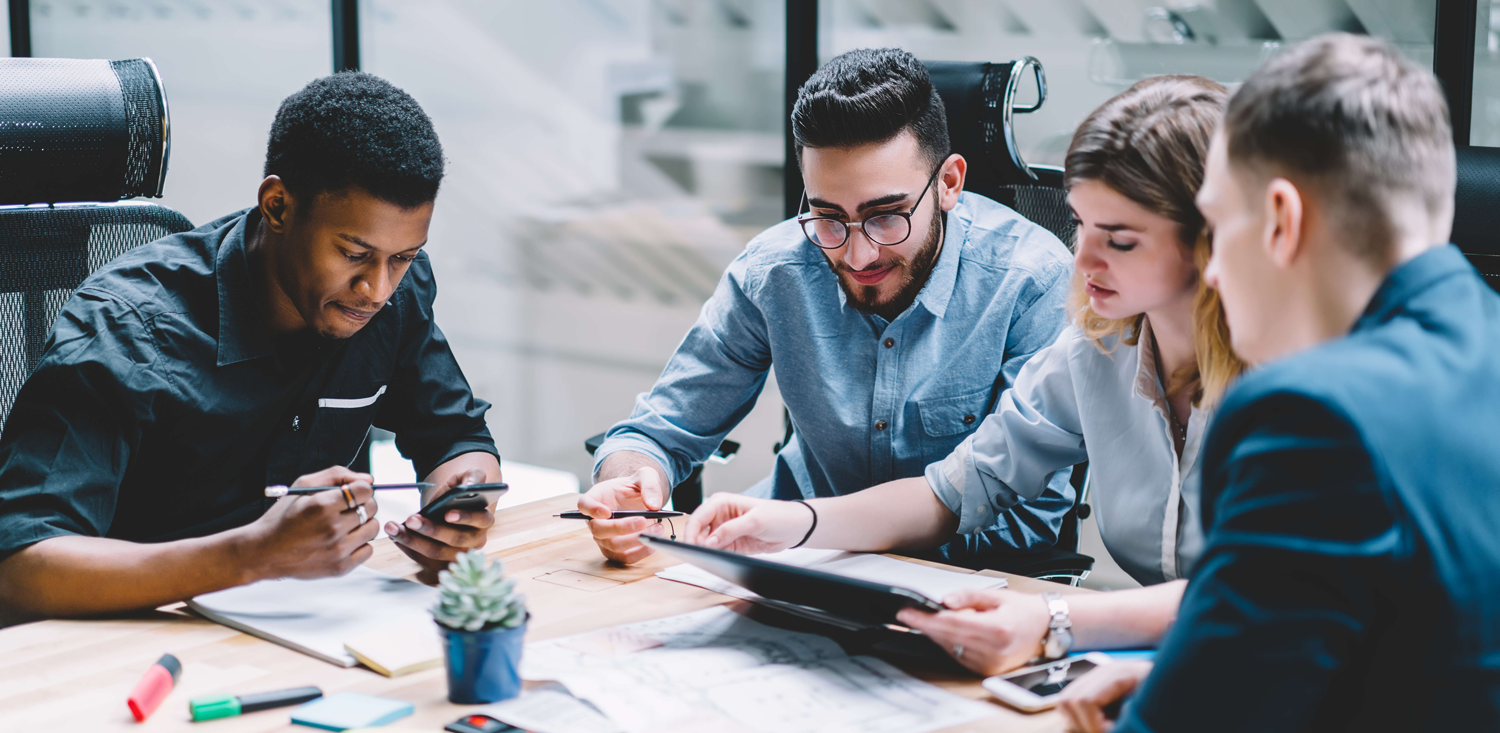 Vier Personen diskutieren an einem Konferenztisch