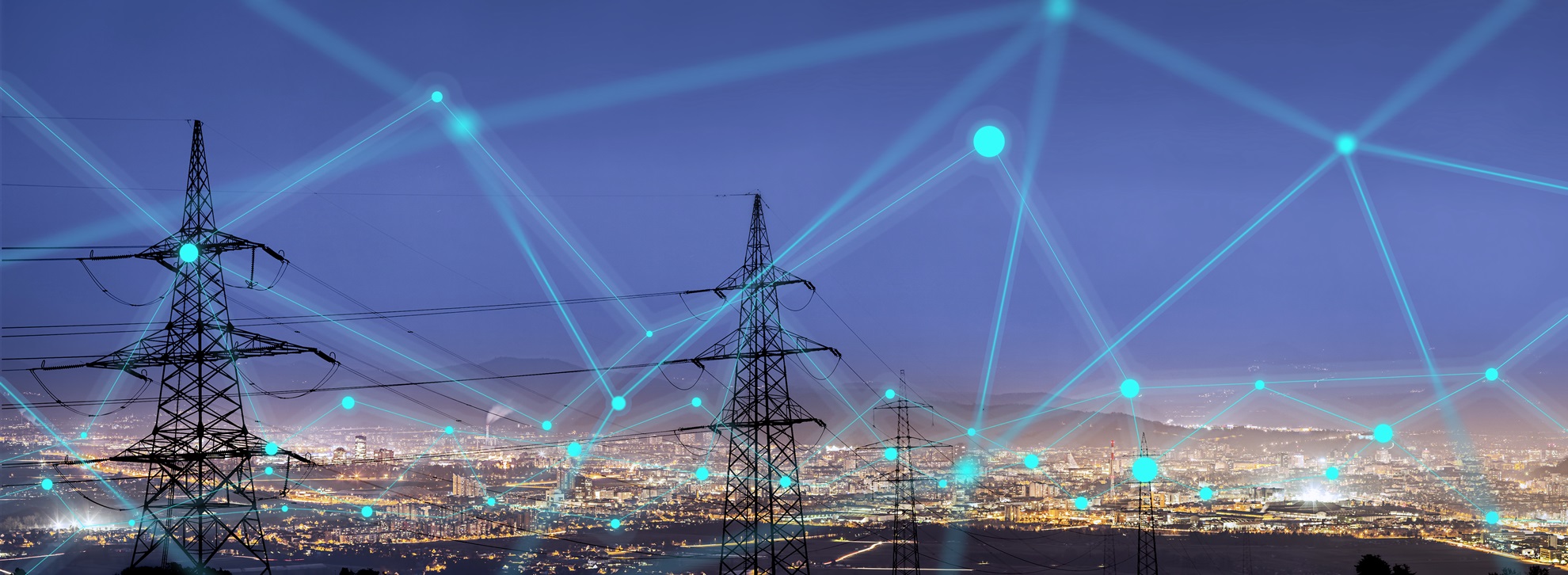 High voltage masts in front of a city at night
