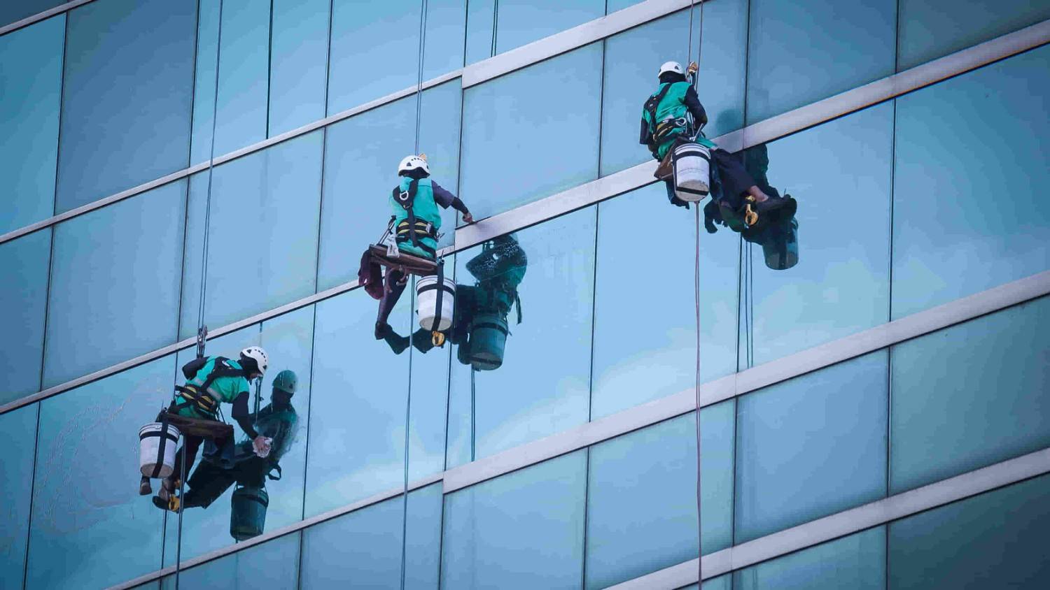 Gruppe von Arbeitern, die Fenster putzen 