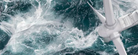 Drohnenaufnahme einer Offshore-Windkraftanlage bei stürmischem Wetter